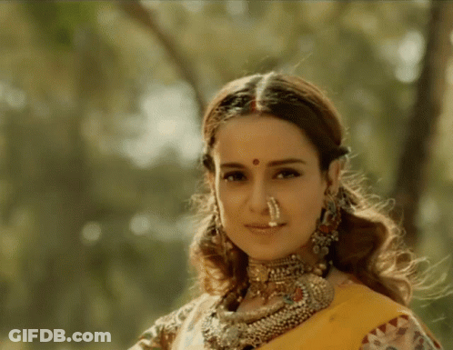 A Woman With A Nose Ring Is Wearing A Yellow Sari GIF