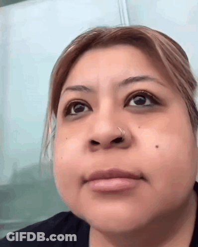 A Woman With A Nose Ring On Her Nose Looks At The Camera GIF