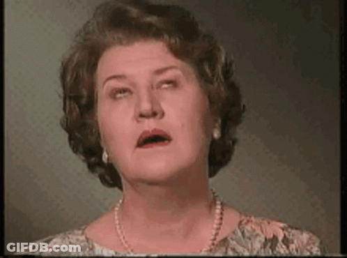 A Woman With A Pearl Necklace Is Making A Funny Face . GIF