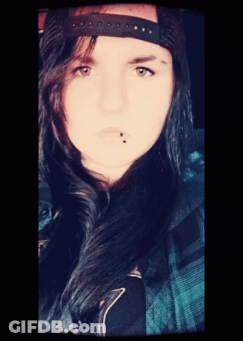 A Woman With A Piercing In Her Lip And A Hat On Her Head GIF