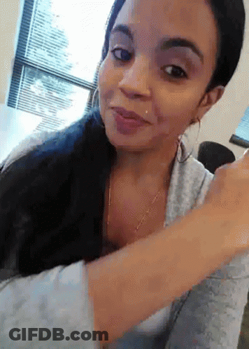 A Woman With A Piercing In Her Nose Is Smiling And Looking At The Camera GIF