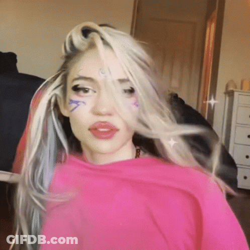 A Woman With A Pink Shirt On Has A Tattoo On Her Forehead That Says ' A ' GIF