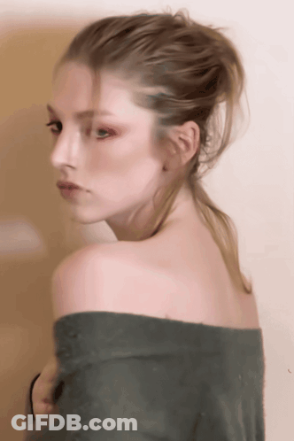 A Woman With A Ponytail Is Wearing A Green Off The Shoulder Sweater GIF