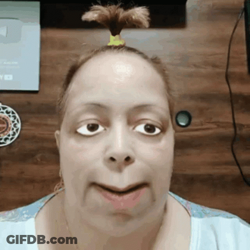 A Woman With A Ponytail On Her Head Is Looking At The Camera GIF