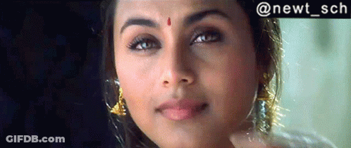 A Woman With A Red Dot On Her Forehead Is Smiling GIF