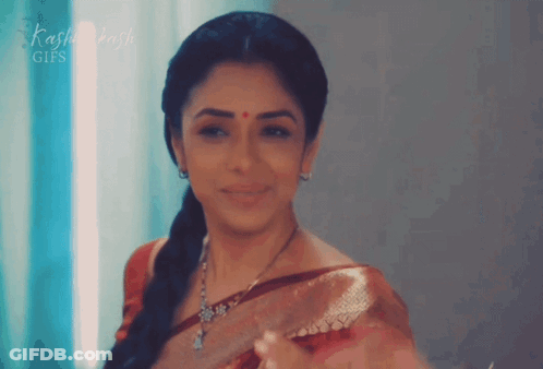A Woman With A Red Dot On Her Forehead Is Smiling In Front Of A Sign That Says Kashi Dash GIF