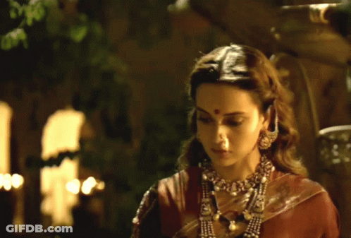 A Woman With A Red Dot On Her Forehead Is Wearing A Necklace GIF