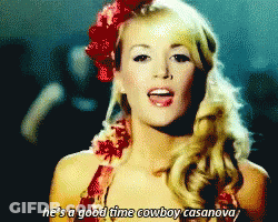 A Woman With A Red Flower In Her Hair Sings He 'S A Good Time Cowboy Casanova GIF