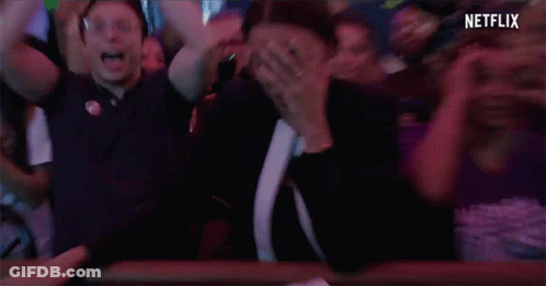 A Woman With A Ring On Her Finger Is Covering Her Mouth In A Crowd Of People With Netflix Written On The Bottom GIF