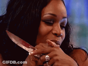 A Woman With A Ring On Her Finger Is Holding A Knife In Her Hand . GIF