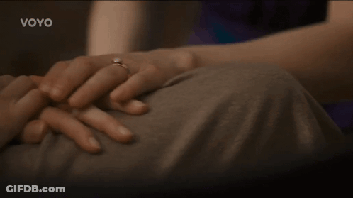 A Woman With A Ring On Her Finger Is Holding A Man 'S Hand With The Word Voyo On The Bottom GIF