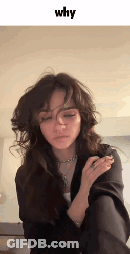 A Woman With A Ring On Her Finger Is Looking At The Camera With The Word Why Above Her GIF