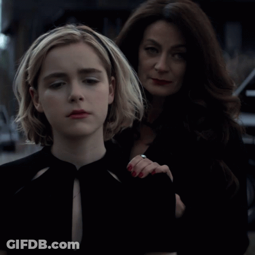 A Woman With A Ring On Her Finger Stands Next To A Girl GIF
