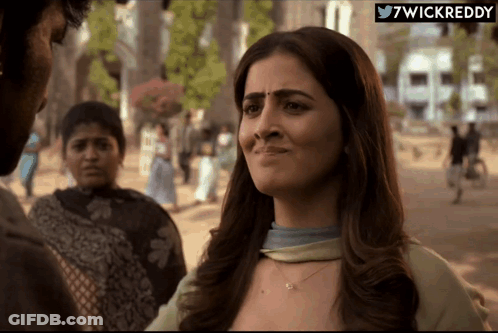 A Woman With A Sad Look On Her Face Is Standing In Front Of A Sign That Says ' 7Wickreddy ' On It GIF