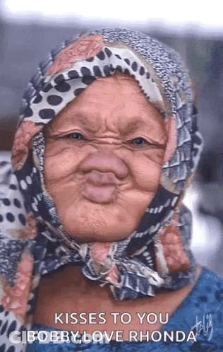 A Woman With A Scarf Around Her Head Is Making A Funny Face . GIF