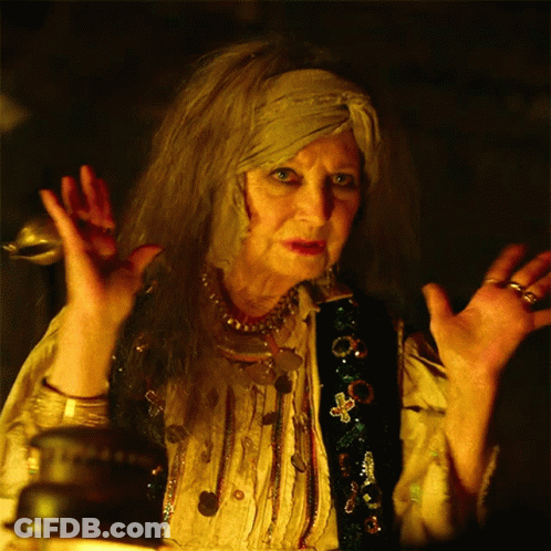 A Woman With A Scarf Around Her Head Is Making A Strange Gesture GIF