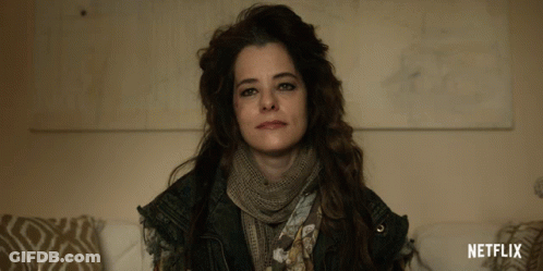 A Woman With A Scarf Around Her Neck And A Netflix Logo On The Bottom GIF