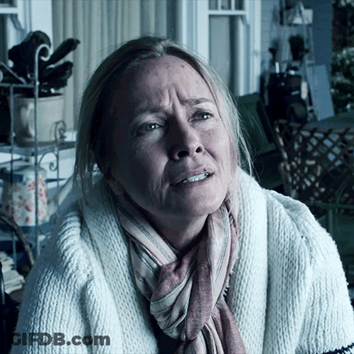 A Woman With A Scarf Around Her Neck And A White Sweater GIF