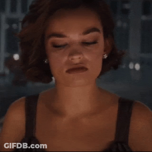 A Woman With A Serious Look On Her Face Wearing Earrings GIF