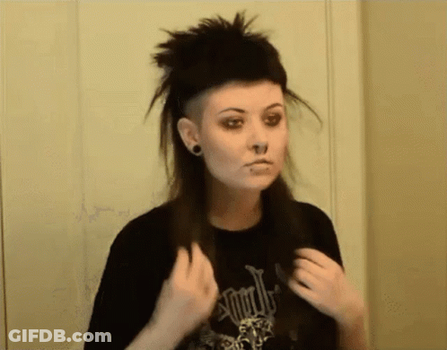 A Woman With A Shaved Head And A Black Shirt That Says ' Apocalypse ' On It GIF