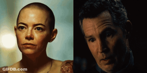 A Woman With A Shaved Head Is Next To A Man With Gray Hair GIF