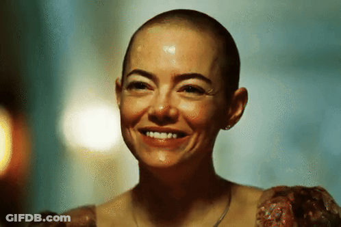 A Woman With A Shaved Head Is Smiling With Blood On Her Face GIF