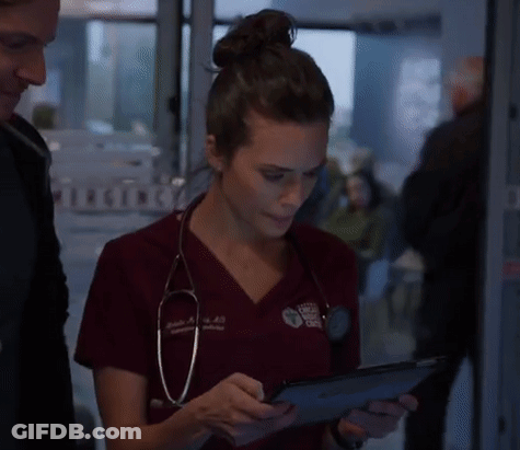 A Woman With A Stethoscope Around Her Neck Is Using A Tablet GIF