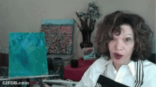 A Woman With A Surprised Look On Her Face Is Holding A Book GIF