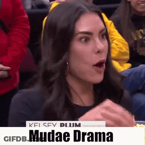 A Woman With A Surprised Look On Her Face Is Sitting In A Crowd With The Words Mudae Drama On The Bottom GIF