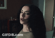 A Woman With A Surprised Look On Her Face Is Standing In A Dark Room GIF