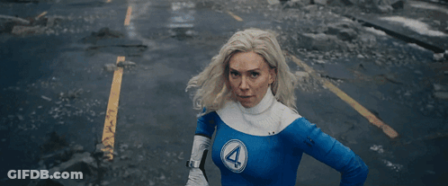 A Woman With A Surprised Look On Her Face Is Standing In Front Of A Painting . GIF