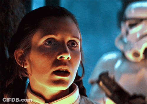 A Woman With A Surprised Look On Her Face Stands In Front Of A Storm Trooper GIF