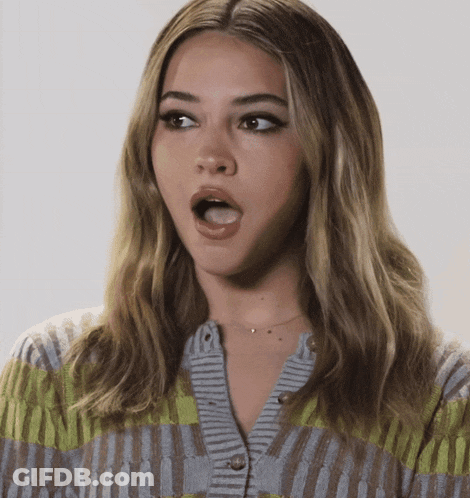 A Woman With A Surprised Look On Her Face Wearing A Cardigan GIF