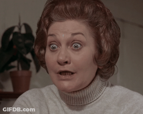 A Woman With A Surprised Look On Her Face Wearing A White Sweater GIF