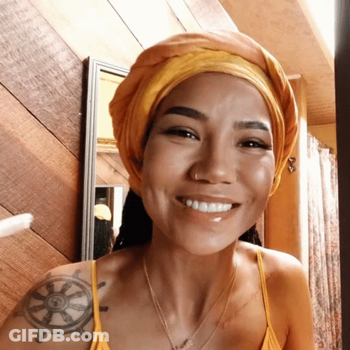 A Woman With A Tattoo Of A Steering Wheel On Her Shoulder Smiles GIF