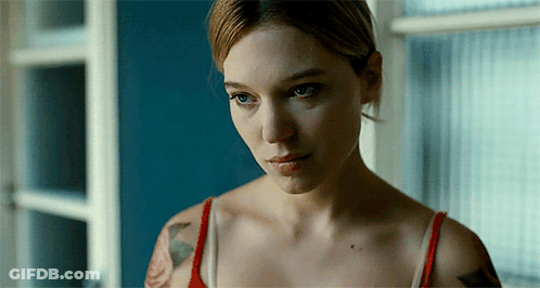 A Woman With A Tattoo On Her Arm Is Looking Out Of A Window GIF
