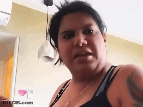 A Woman With A Tattoo On Her Arm Is Making A Face GIF