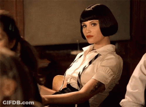 A Woman With A Tattoo On Her Arm Is Wearing A White Shirt And Black Tie GIF