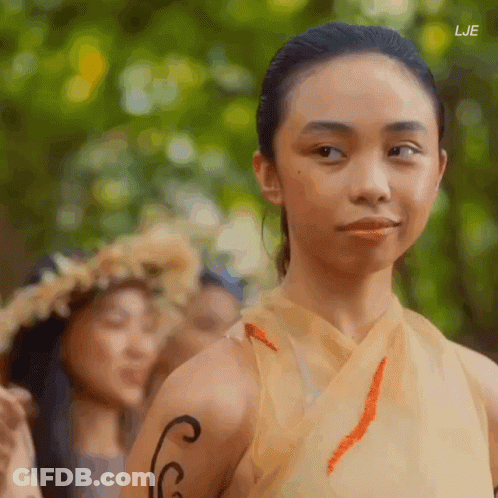 A Woman With A Tattoo On Her Arm Looks At The Camera With The Letters Lje Visible In The Corner GIF