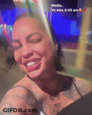 A Woman With A Tattoo On Her Chest Is Smiling And Says Nadie GIF