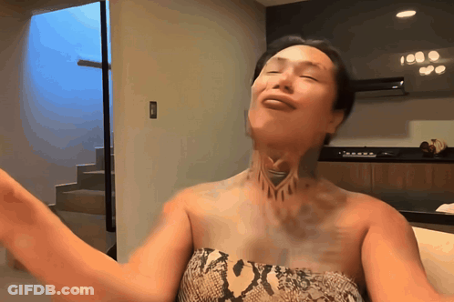 A Woman With A Tattoo On Her Neck Is Dancing GIF