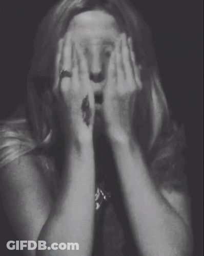 A Woman With A Tattoo On Her Wrist Covering Her Face GIF