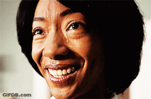 A Woman With A Tear Running Down Her Face Is Smiling GIF