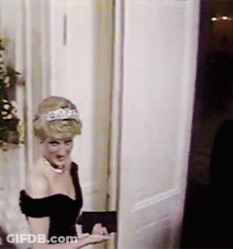 A Woman With A Tiara On Her Head Is Standing In A Doorway GIF