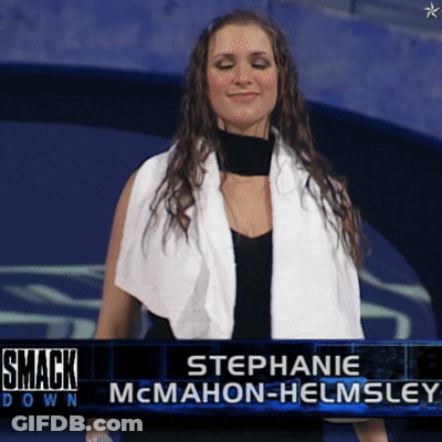 A Woman With A Towel Around Her Neck Is Standing In Front Of A Smack Down Sign GIF