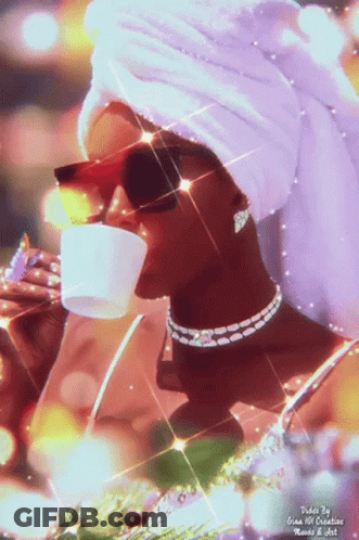 A Woman With A Towel Wrapped Around Her Head Drinks From A Cup GIF