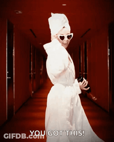 A Woman With A Towel Wrapped Around Her Head Is Walking Down A Hallway With The Words You Got This Behind Her GIF