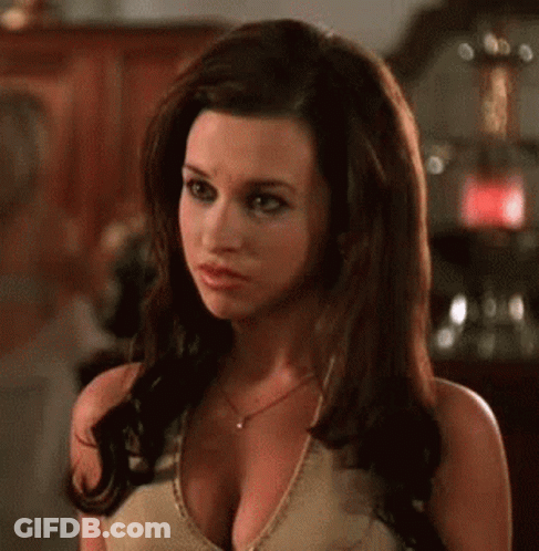A Woman With A Very Large Breast Is Wearing A Necklace And A Tank Top . GIF