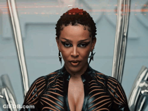 A Woman With A Very Plunging Neckline And A Star Earring Looks At The Camera GIF