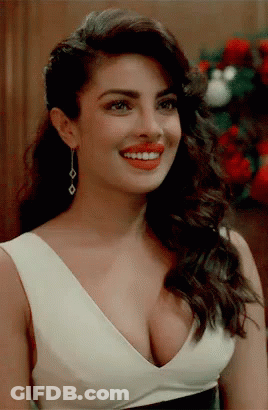A Woman With A Very Plunging Neckline Is Smiling And Wearing Red Lipstick GIF